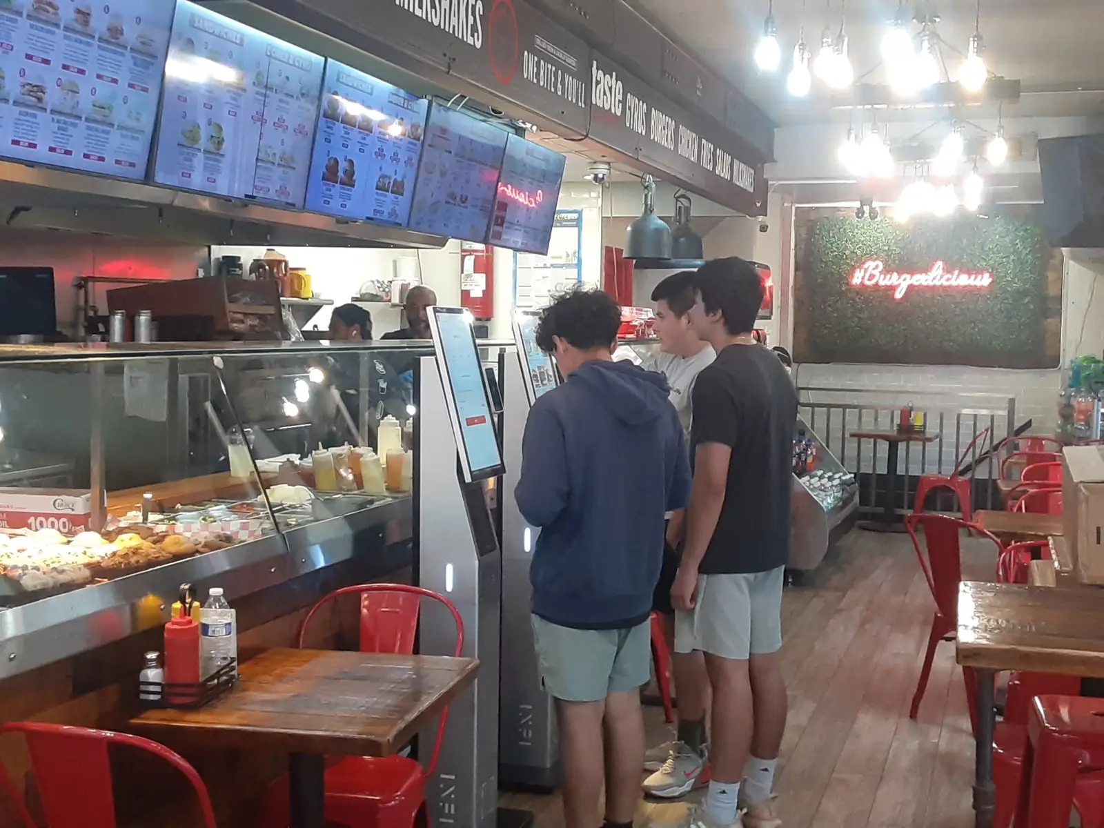 Customers ordering at BurgerMan kiosk